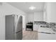 Clean kitchen featuring stainless steel fridge and stove, modern backsplash, and white cabinetry at 541 W Vernon Ave, Phoenix, AZ 85003