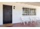 Inviting covered porch with barred windows, outdoor lighting, seating, and a classic brick exterior at 541 W Vernon Ave, Phoenix, AZ 85003