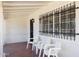 Cozy covered porch with barred windows, seating and a white brick exterior wall at 541 W Vernon Ave, Phoenix, AZ 85003