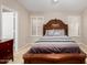 Spacious bedroom featuring tiled floor, shutters, ceiling fan, and a large dark wood bed with bedside tables at 6631 E Rhodes St, Mesa, AZ 85215