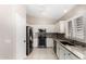Modern kitchen with stainless steel appliances, granite countertops, and white cabinetry at 6631 E Rhodes St, Mesa, AZ 85215