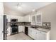 Bright kitchen features white cabinetry, granite countertops, modern appliances, and tiled backsplash at 6631 E Rhodes St, Mesa, AZ 85215