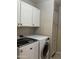 Laundry room with front loading washer and dryer and built-in cabinets for storage at 6631 E Rhodes St, Mesa, AZ 85215