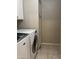 Laundry room with front loading washer and dryer and built-in cabinets for storage at 6631 E Rhodes St, Mesa, AZ 85215