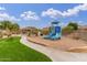 Community playground area with slides and artificial turf creating a safe space for recreation at 6631 E Rhodes St, Mesa, AZ 85215