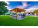 Stunning backyard with built-in BBQ, bar seating, lush artificial turf, and pool at 6831 E Presidio Rd, Scottsdale, AZ 85254