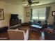 Cozy living room with plush seating, a ceiling fan, and a large window, perfect for relaxing and entertaining at 7251 E Grouse Ct, San Tan Valley, AZ 85143