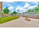 Lush backyard features a brick patio, garden area, a fire pit, green grass, palm trees and blue skies at 747 E Meadow Ln, Phoenix, AZ 85022