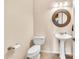 Powder room featuring a pedestal sink and round mirror, with neutral paint at 747 E Meadow Ln, Phoenix, AZ 85022