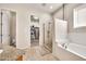 Bathroom with glass enclosed shower, soaking tub, and doorway to walk-in closet at 747 E Meadow Ln, Phoenix, AZ 85022