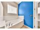 Bright bathroom featuring a built in tub below a window, next to a painted blue wall at 747 E Meadow Ln, Phoenix, AZ 85022