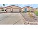 Inviting single-story home featuring a three-car garage and desert landscaping at 747 E Meadow Ln, Phoenix, AZ 85022