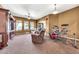 Spacious living room featuring neutral carpet, a ceiling fan, three windows, a drum set and two brown reclining sofas at 747 E Meadow Ln, Phoenix, AZ 85022