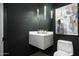 Contemporary powder room with a marble sink, modern light fixture, and a white toilet at 7614 E Cactus Wren Rd, Scottsdale, AZ 85250
