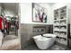 Modern bathroom featuring a sleek white tub, gray tiled accent wall with decor, and built-in towel shelving at 7614 E Cactus Wren Rd, Scottsdale, AZ 85250