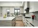 Modern kitchen featuring white cabinets, a marble countertop island, and a convenient cooktop, perfect for culinary enthusiasts at 7614 E Cactus Wren Rd, Scottsdale, AZ 85250