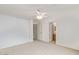 Neutral bedroom with carpet, featuring a ceiling fan, closet, and an en-suite bathroom at 8924 E Portobello Ave, Mesa, AZ 85212