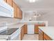 Bright kitchen featuring wood cabinets, white appliances, and an open view into the living room at 8924 E Portobello Ave, Mesa, AZ 85212