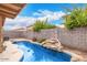 Backyard pool area with waterfall feature, privacy wall, and lush landscaping at 8924 E Portobello Ave, Mesa, AZ 85212