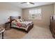 A cozy bedroom is furnished with a queen bed, soft carpeting, and a window with plantation shutters at 9834 E Thatcher Ave, Mesa, AZ 85212