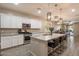 A modern kitchen features white cabinets, stainless appliances, and a large island with bar seating and granite countertops at 9834 E Thatcher Ave, Mesa, AZ 85212