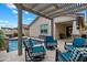 Inviting backyard patio area with cushioned outdoor furniture, covered pergola, and nearby pool and hot tub at 9834 E Thatcher Ave, Mesa, AZ 85212