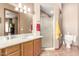 Well-lit bathroom features a single sink vanity, a walk-in shower with glass door, and neutral color tones at 988 W Crooked Stick Dr, Casa Grande, AZ 85122