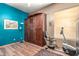 Bright room with blue accent wall, murphy bed, workout equipment, and hardwood floors at 988 W Crooked Stick Dr, Casa Grande, AZ 85122