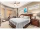 Cozy bedroom with plush bedding, a ceiling fan, and natural light filtering through the window blinds at 988 W Crooked Stick Dr, Casa Grande, AZ 85122