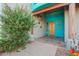 Inviting entryway showing a decorative wood door, unique turquoise paint and lush landscaping at 988 W Crooked Stick Dr, Casa Grande, AZ 85122