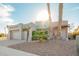 Inviting exterior showcases desert landscaping, a two-car garage, and a charming facade with an eye-catching pop of color at 988 W Crooked Stick Dr, Casa Grande, AZ 85122