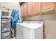 Functional laundry room with front load washer and dryer and convenient cabinet storage at 988 W Crooked Stick Dr, Casa Grande, AZ 85122