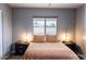 Comfortable bedroom with neutral colors, side tables and lamps, and a large window at 1017 W Piccadilly Rd, Phoenix, AZ 85013