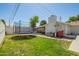 Spacious backyard features a trampoline, a shed, green grass, and a white fence, ideal for outdoor enjoyment at 1020 E Vermont Ave, Phoenix, AZ 85014