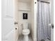 Bright bathroom featuring a toilet, patterned tile flooring, and a white and gray shower curtain for a clean look at 1020 E Vermont Ave, Phoenix, AZ 85014
