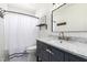 Bathroom features a vanity with a marble countertop, modern fixtures, and a shower with a white curtain at 1020 E Vermont Ave, Phoenix, AZ 85014