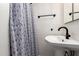 A bathroom features a sleek white sink, a black faucet, and a decorative shower curtain at 1020 E Vermont Ave, Phoenix, AZ 85014