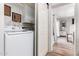 Bright laundry area with a washer and dryer, white cabinets for storage, and a view into the hallway at 1020 E Vermont Ave, Phoenix, AZ 85014