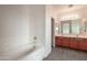 Bright bathroom featuring a soaking tub and a double sink vanity with wood cabinets at 1036 E Magnum Rd, San Tan Valley, AZ 85140