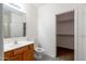 This bathroom features a wood vanity with a sink and mirror plus a toilet and doorway to the walk-in closet at 1036 E Magnum Rd, San Tan Valley, AZ 85140