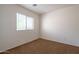 Clean bedroom with neutral carpet and a bright window provides natural light at 1036 E Magnum Rd, San Tan Valley, AZ 85140