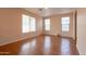 Bright and airy living room with wood look floors and large windows providing natural light at 1036 E Magnum Rd, San Tan Valley, AZ 85140
