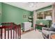 A bright bedroom with a crib and a green painted wall at 1170 E Carmen St, Tempe, AZ 85283