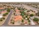 Overhead view of desert homes featuring terracotta roofs and landscaped yards near a highway at 12899 W Pasadena Ave, Litchfield Park, AZ 85340
