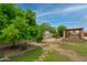 Backyard featuring a covered gazebo, mature trees, grass and gravel at 12899 W Pasadena Ave, Litchfield Park, AZ 85340