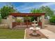Charming backyard with a covered patio and water fountain, ideal for outdoor relaxation and entertaining at 12899 W Pasadena Ave, Litchfield Park, AZ 85340