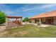 Expansive backyard featuring a covered patio, well-maintained lawn, and a tiled roof at 12899 W Pasadena Ave, Litchfield Park, AZ 85340