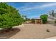 Expansive backyard showcasing a covered patio and mature trees, offering a private and peaceful outdoor retreat at 12899 W Pasadena Ave, Litchfield Park, AZ 85340