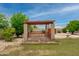 Charming backyard featuring a covered patio, mature trees, and lush landscaping, perfect for outdoor relaxation at 12899 W Pasadena Ave, Litchfield Park, AZ 85340