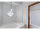 View of bathtub and shower in light and bright bathroom with stylish fixtures at 12899 W Pasadena Ave, Litchfield Park, AZ 85340